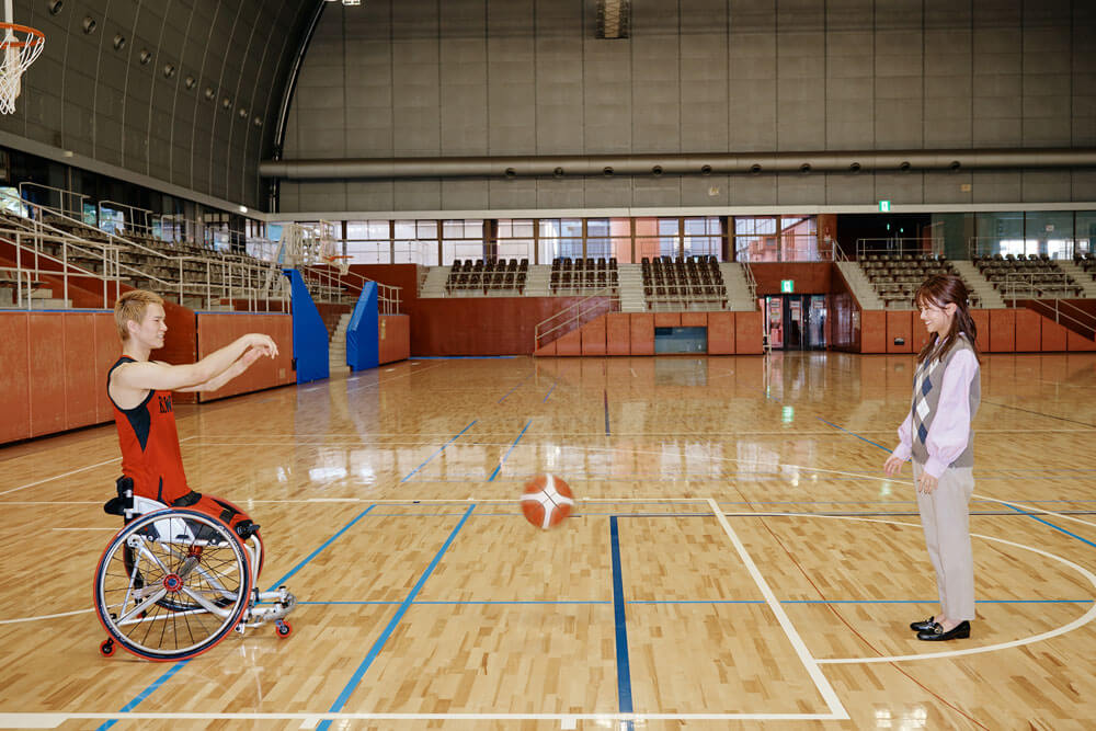 写真：車いすバスケットボール鳥海連志選手と、中川絵美里キャスターがコート上でバスケットボールをパスし合う様子