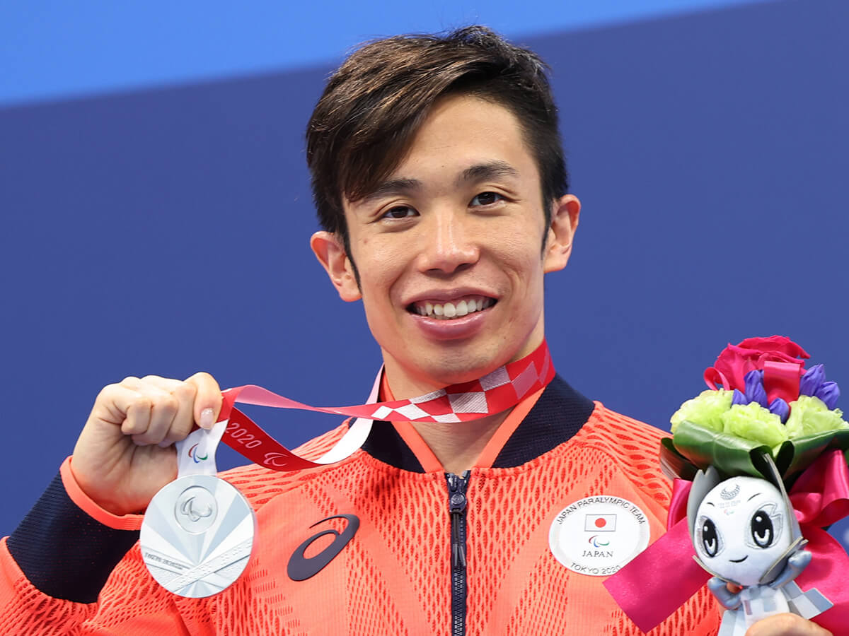 写真：東京パラリンピックで銀メダルを首からさげ、笑顔で撮影に応じるパラ競泳・富田宇宙選手