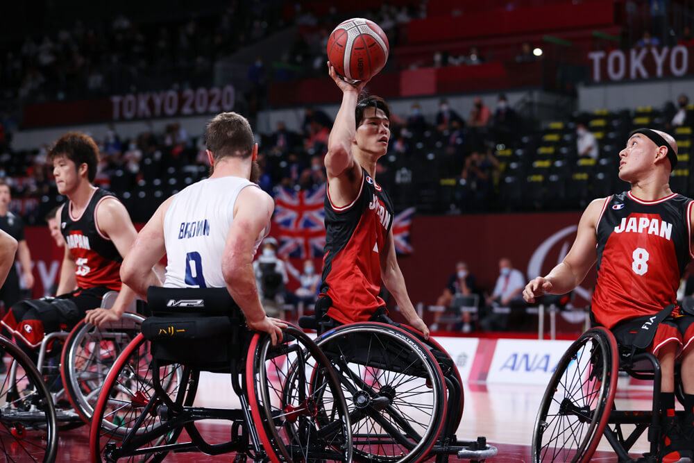 写真：試合中にバスケットボールを右手で頭上に持つ、車いすバスケットボール鳥海連志選手