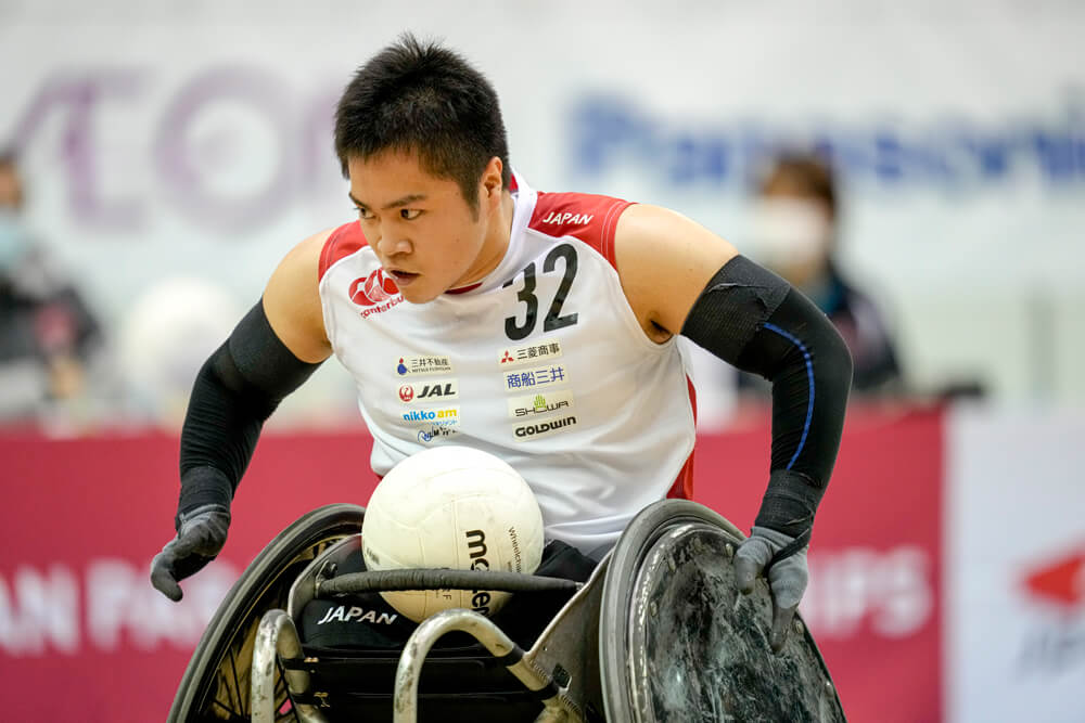 写真：ボールを腿の上にのせ車いすを移動させる車いすラグビー橋本勝也選手