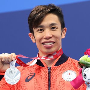 サムネイル写真：写真：東京パラリンピックで銀メダルを首からさげ、笑顔で撮影に応じるパラ競泳・富田宇宙選手