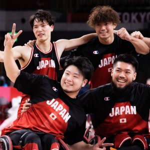 サムネイル用写真：写真：東京2020パラリンピック車いすバスケットボール日本代表・川原凜選手が笑顔でピースをしながら、他の日本人選手たちと集合写真の撮影に応じている様子
