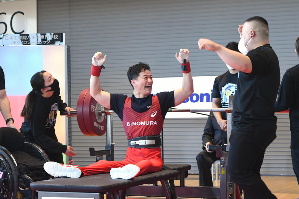 写真：男子49㎏級の西崎哲男選手が日本記録を塗り替える139キロに成功し、JPPFの荒川龍一コーチと喜びを爆発させる様子。