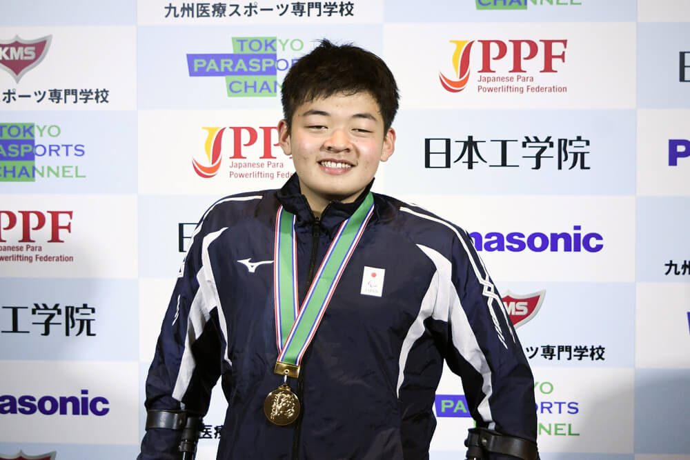 写真：ジュニア男子65㎏級の大宅心季選手。メダルを首から下げ喜びの表情を浮かべている